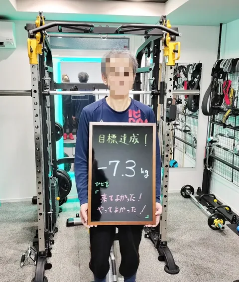 「目標達成！ −7.3kg」と書かれた黒板を持つお客様