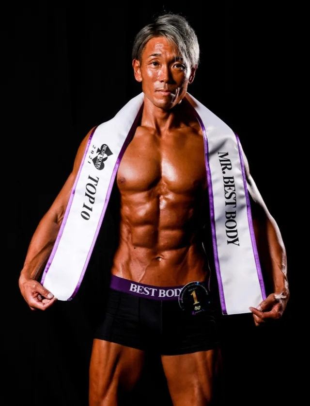 ZKフィットネスのトレーナー 加藤春樹。MR.BEST BODYとTOP10のサッシュを着用している
